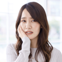 口に痛みを感じる女性