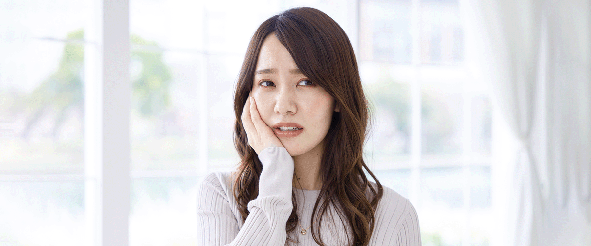 口に痛みを感じる女性