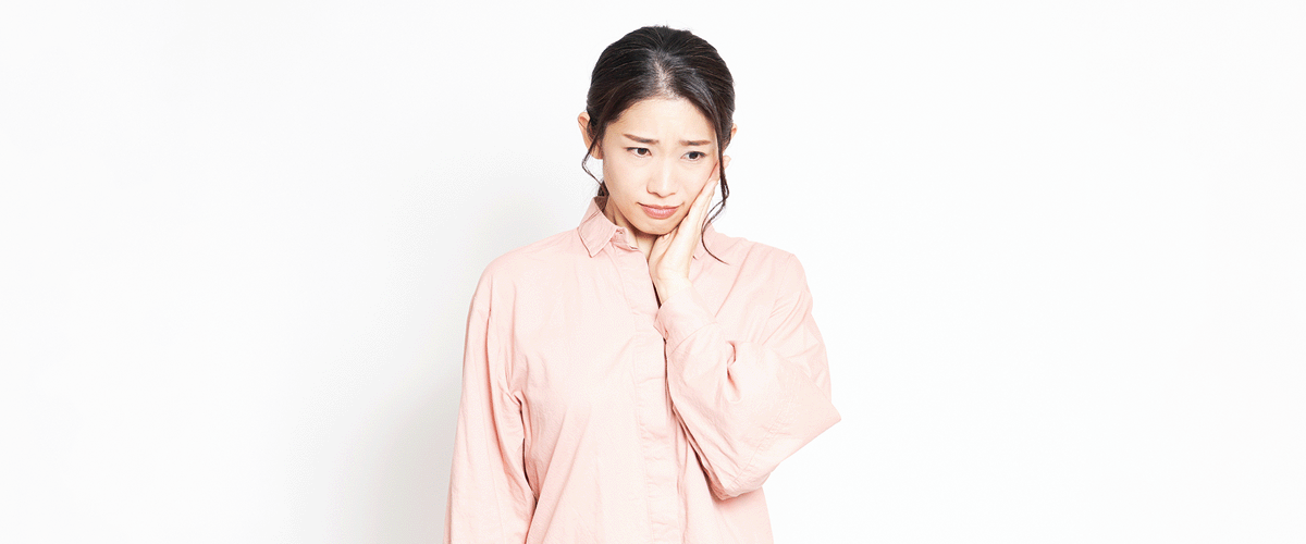 歯が痛みうつむく女性