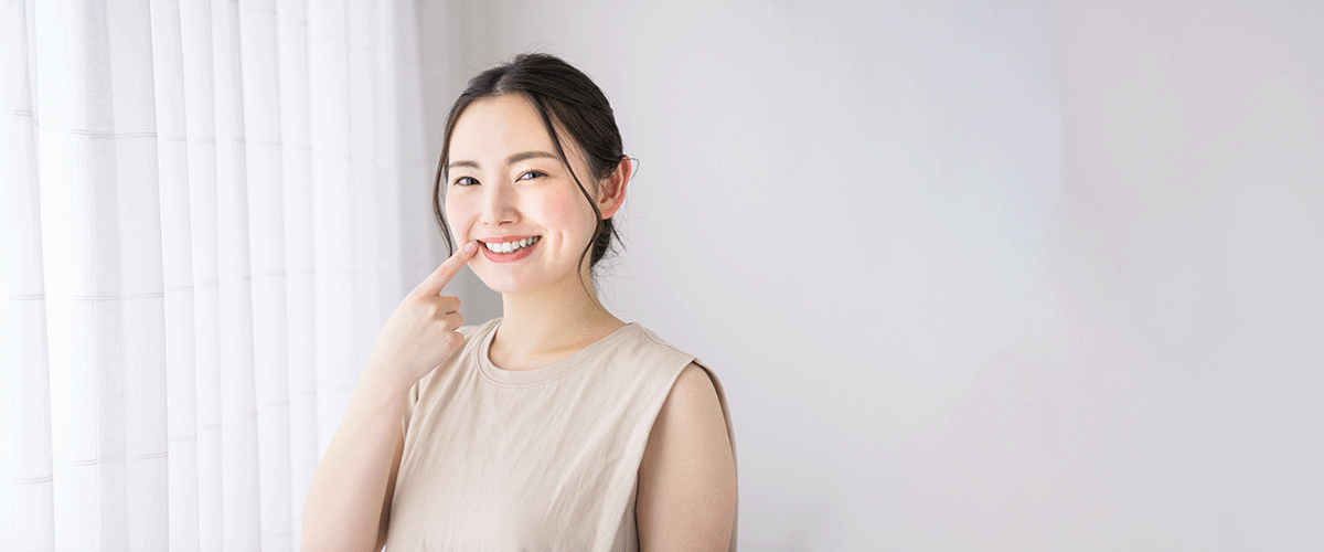 歯を指さす女性