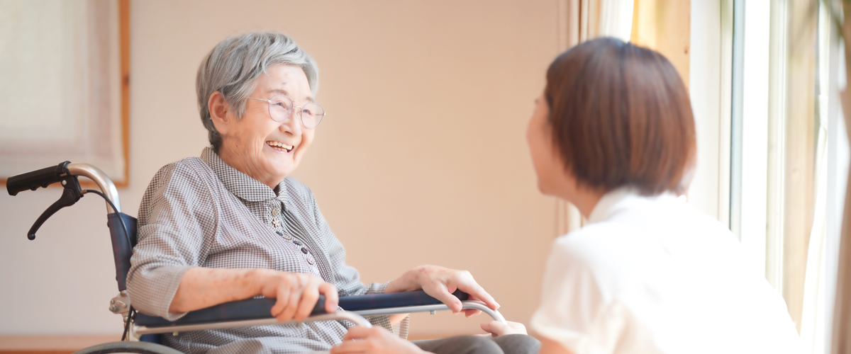高齢女性とコミュニケーションをとるスタッフ